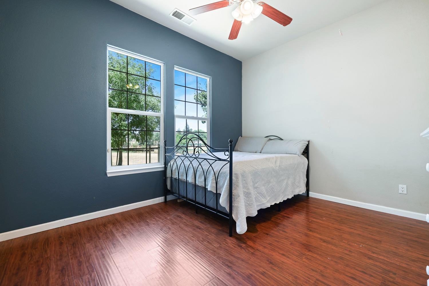 16787 Monreal Road Madera, CA 93636 - Photo 17 of 35 a bedroom with a bed and wooden floor