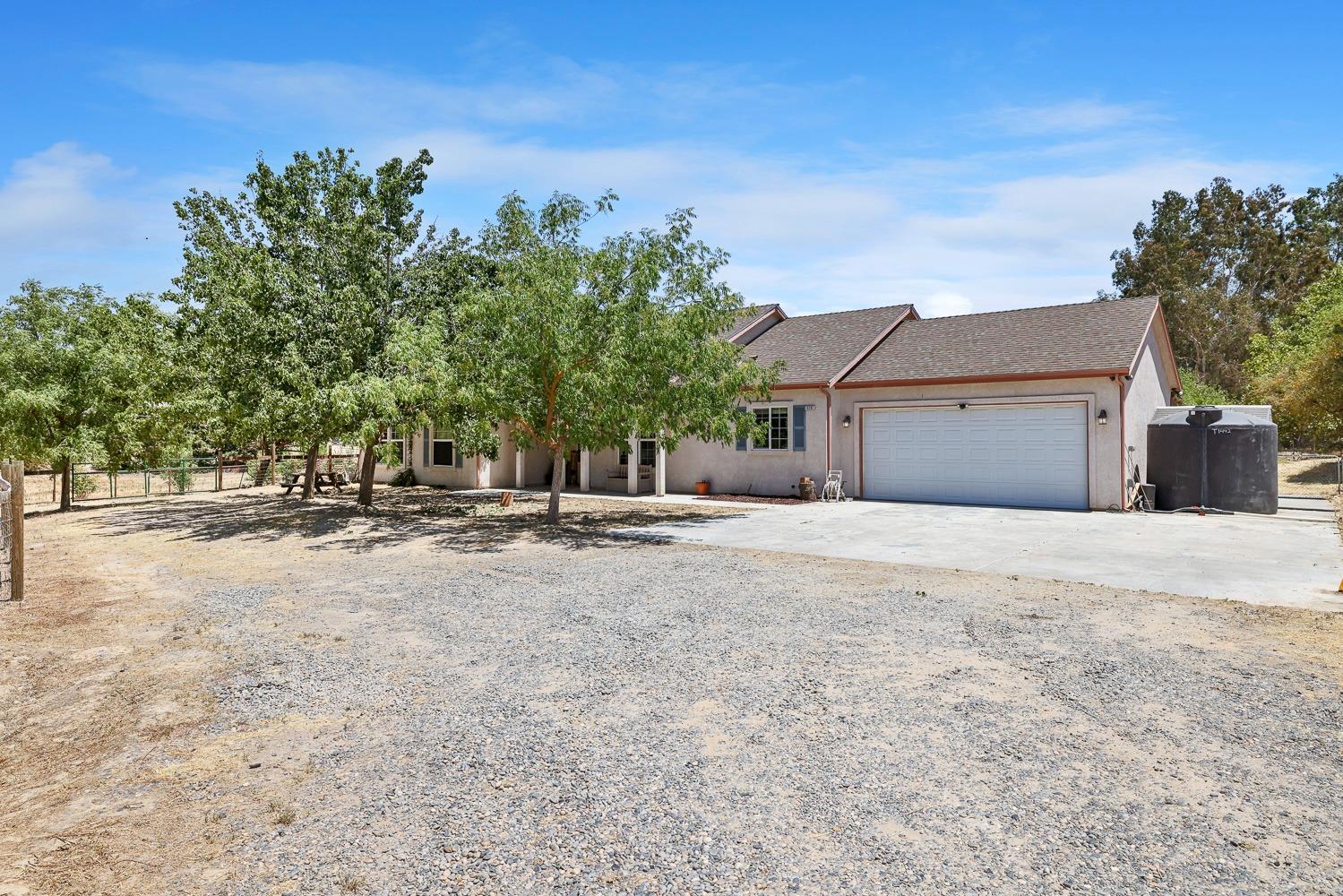 16787 Monreal Road Madera, CA 93636 - Photo 2 of 35 a view of a house with a yard and garage