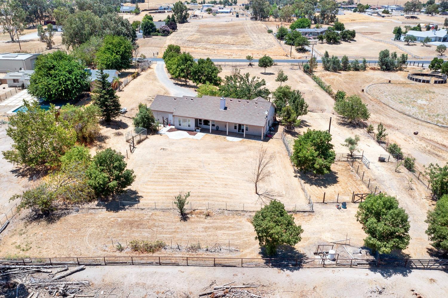 16787 Monreal Road Madera, CA 93636 - Photo 30 of 35 an aerial view of a house with a yard and trees all around