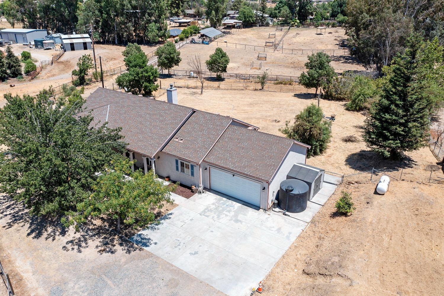 16787 Monreal Road Madera, CA 93636 - Photo 31 of 35 an aerial view of a house with a yard and trees