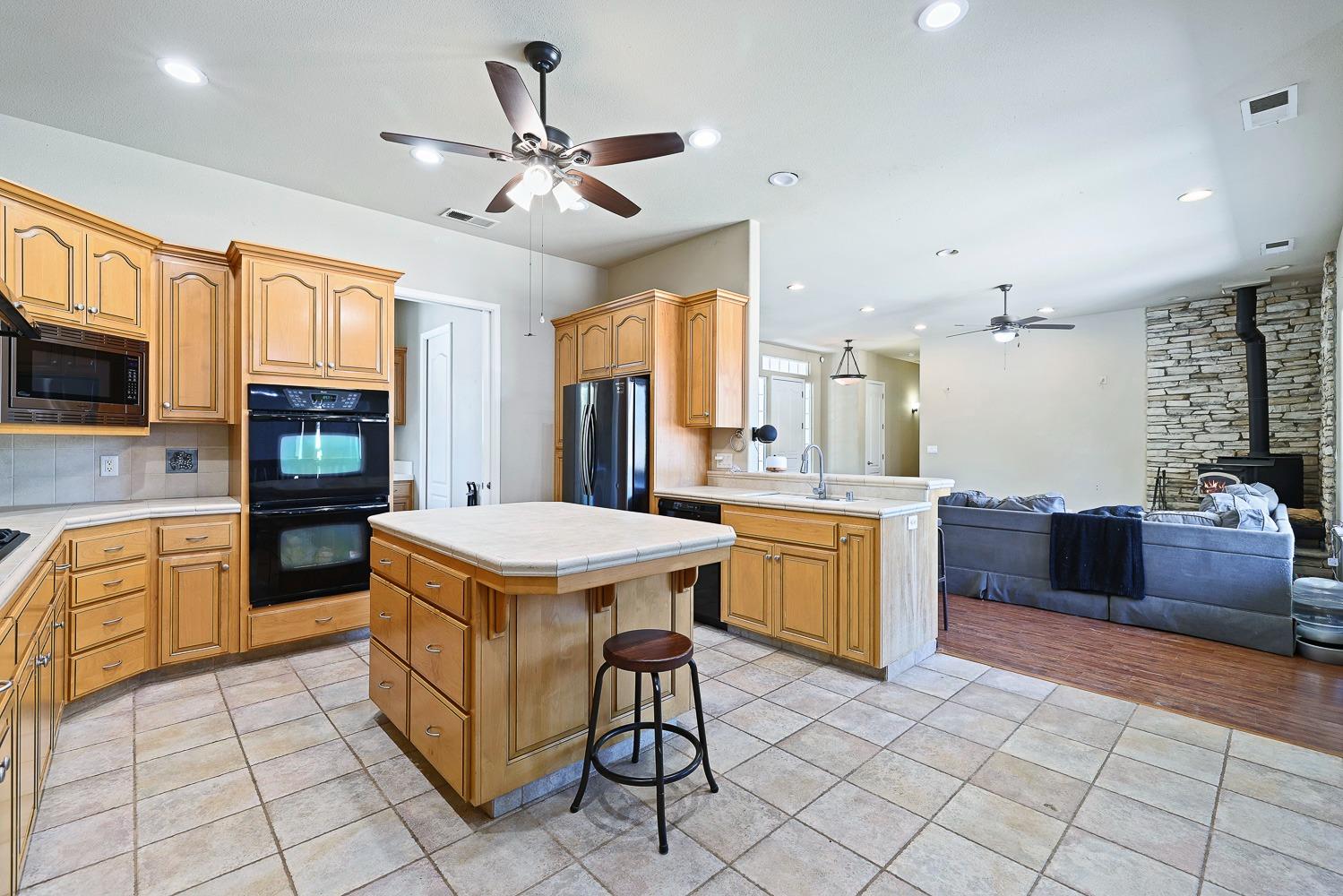 16787 Monreal Road Madera, CA 93636 - Photo 10 of 35 a kitchen that has a lot of cabinets in it and a refrigerator