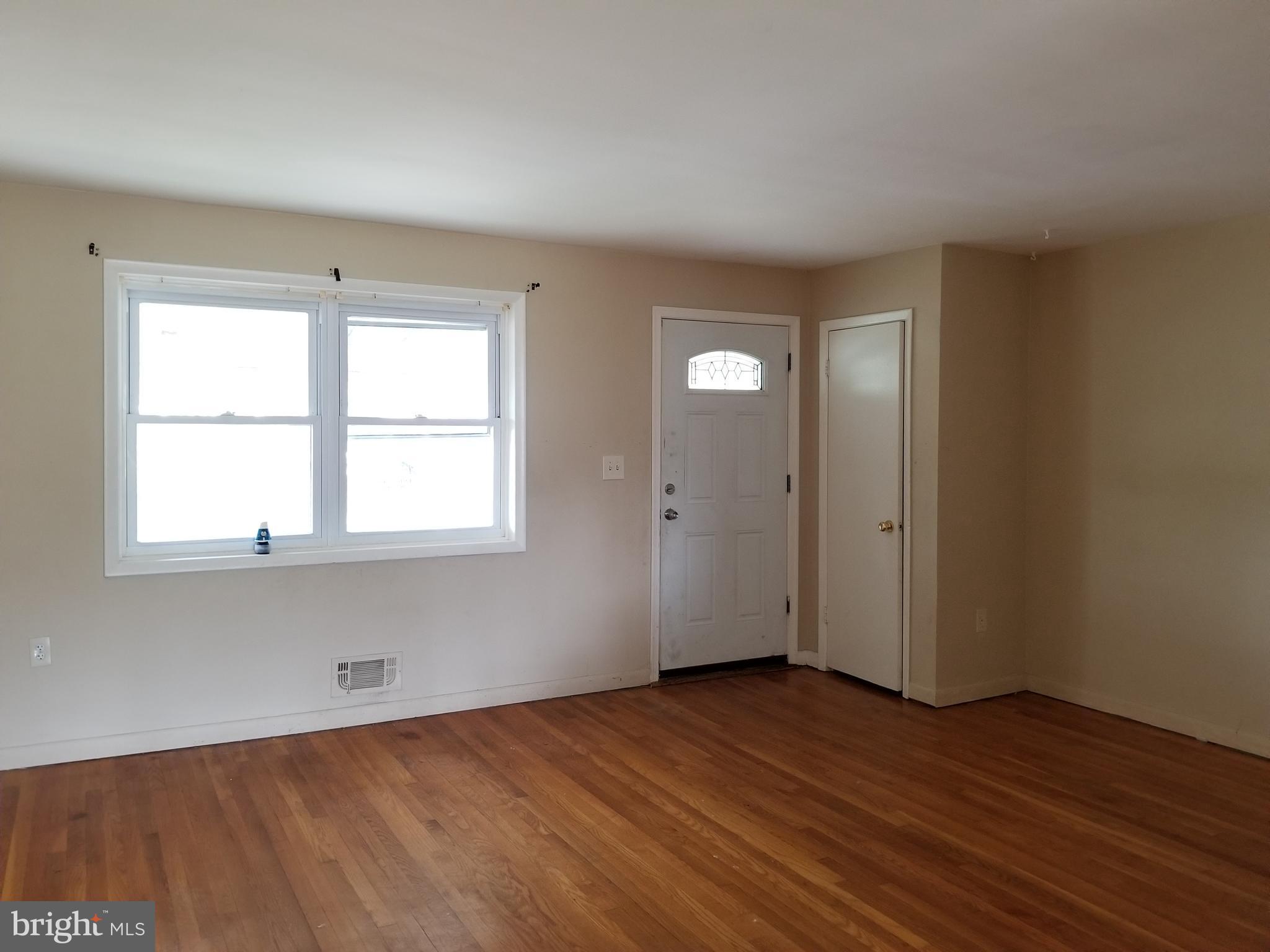9750 Conmar Road Baltimore, MD 21220 - Photo 4 of 20 an empty room with wooden floor and windows