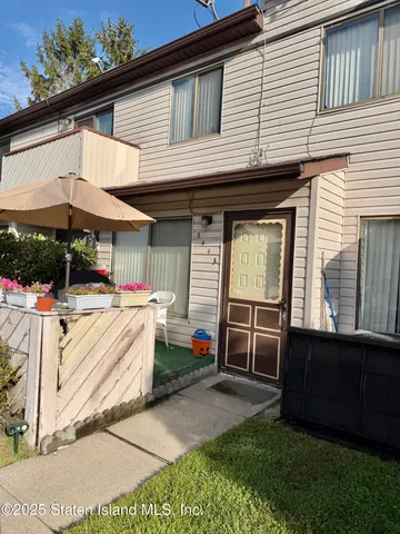a view of a white house with a large window and a yard
