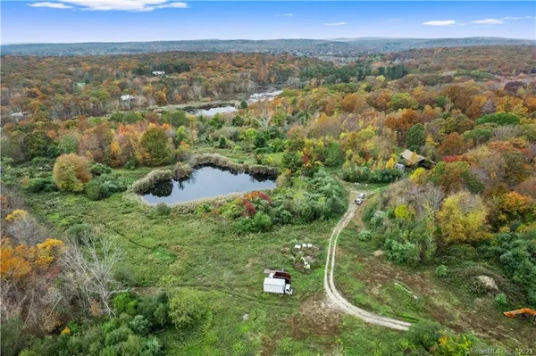 an aerial view of residential houses with outdoor space and trees