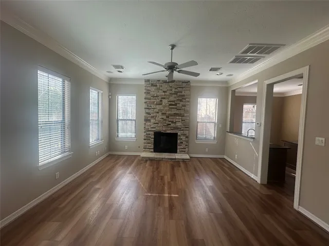 a view of a livingroom with a fireplace wooden floor and a window