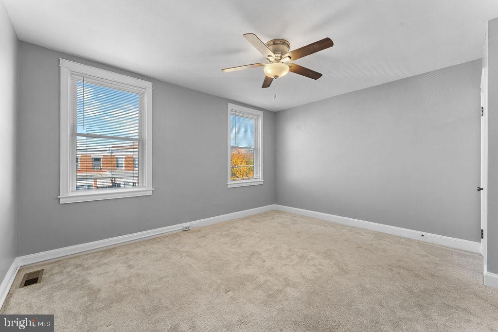 339 Drew Street Baltimore, MD 21224 - Photo 22 of 26 a view of an empty room with chandelier fan and a window