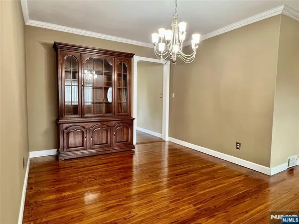 a view of a room with wooden floor and chandelier