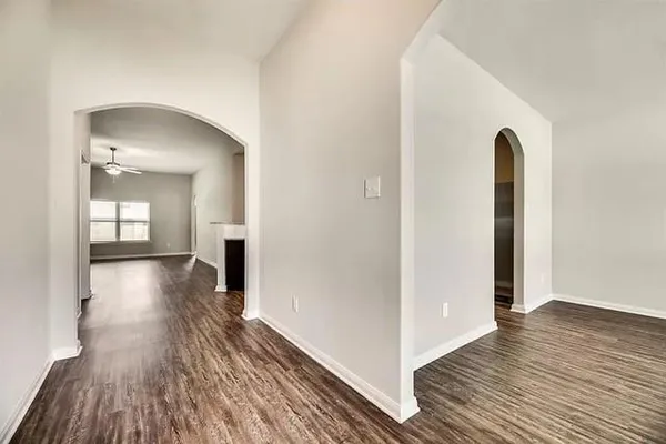 a view of a room with wooden floor and a hallway