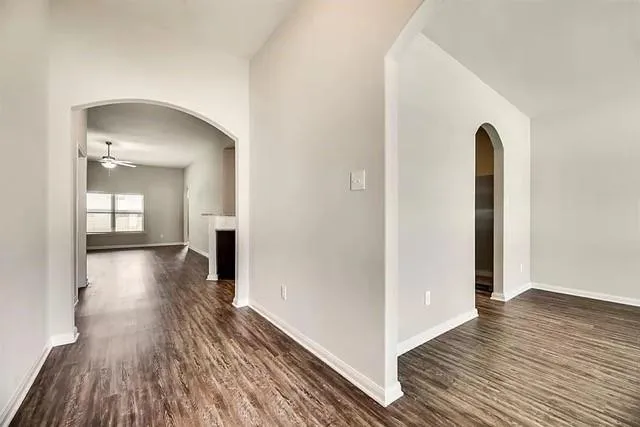 a view of a room with wooden floor and a hallway