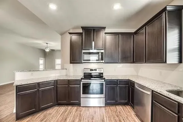 a kitchen with stainless steel appliances wooden cabinets and a stove top oven