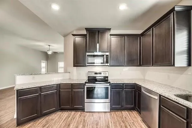 a kitchen with stainless steel appliances wooden cabinets and a stove top oven
