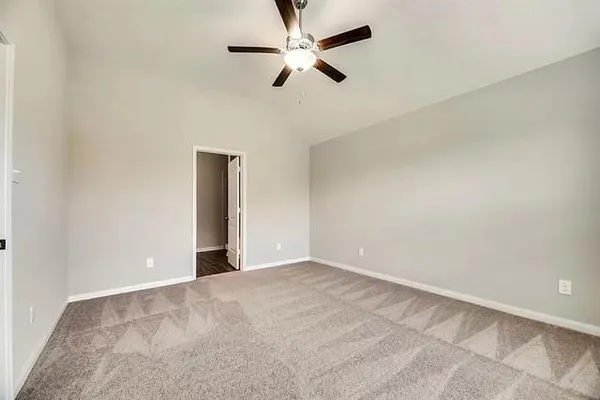 an empty room with chandelier fan