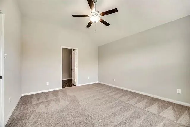 an empty room with chandelier fan