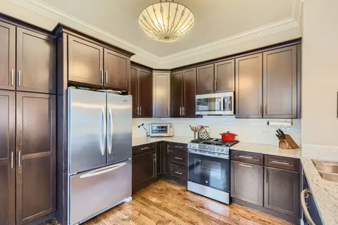 a kitchen with stainless steel appliances a sink and a refrigerator