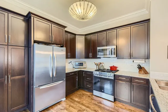 a kitchen with stainless steel appliances a sink and a refrigerator