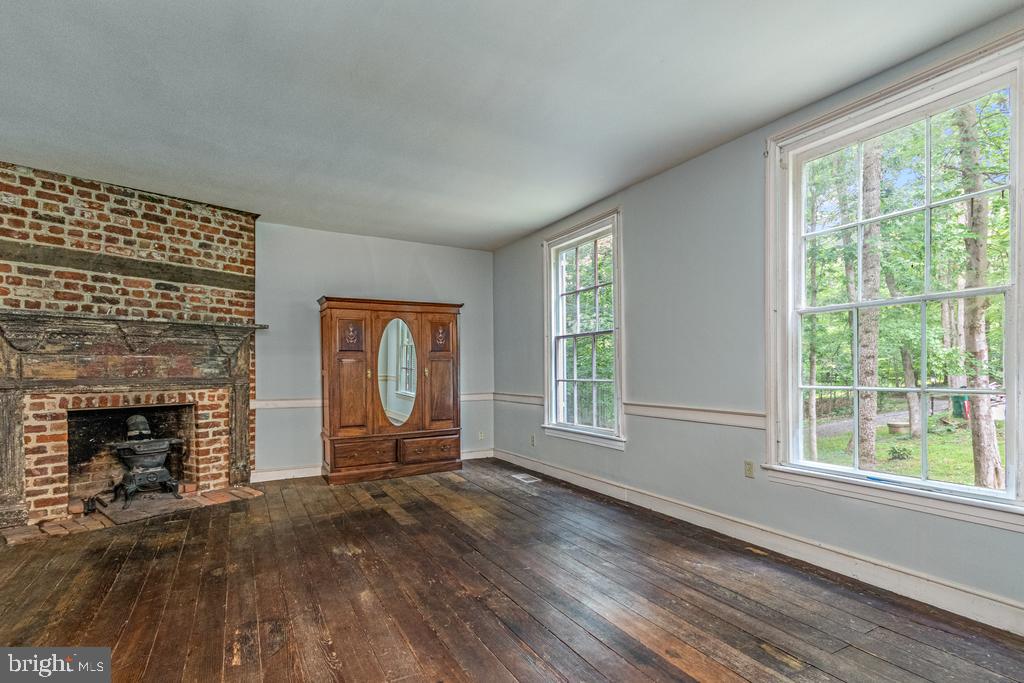 807 Holly Corner Road Fredericksburg, VA 22406 - Photo 14 of 57 an empty room with wooden floor fireplace and windows