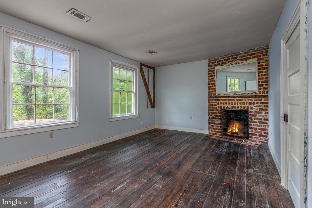 807 Holly Corner Road Fredericksburg, VA 22406 - Photo 15 of 57 a view of an empty room with wooden floor fireplace and a window