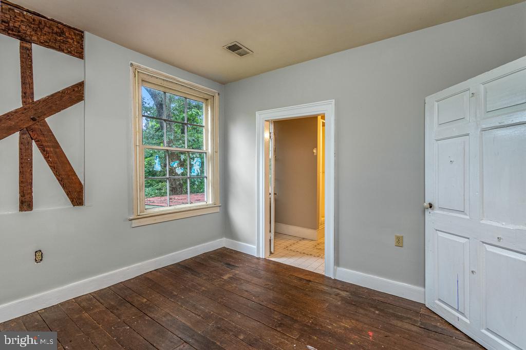 807 Holly Corner Road Fredericksburg, VA 22406 - Photo 17 of 57 a view of an empty room with wooden floor and a window