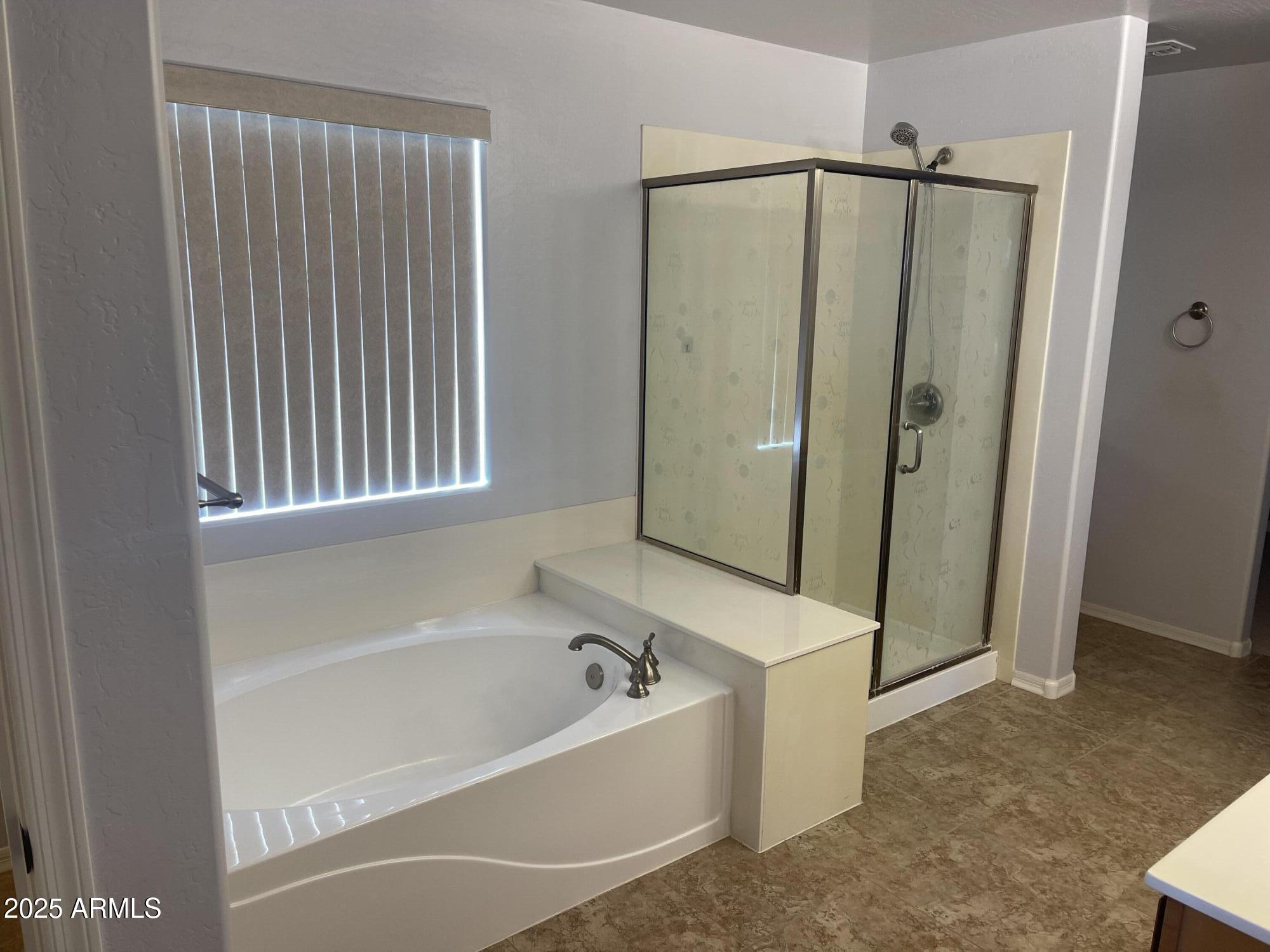 51355 West Century Road Maricopa, AZ 85139 - Photo 13 of 33 a bathroom with a bathtub and a shower