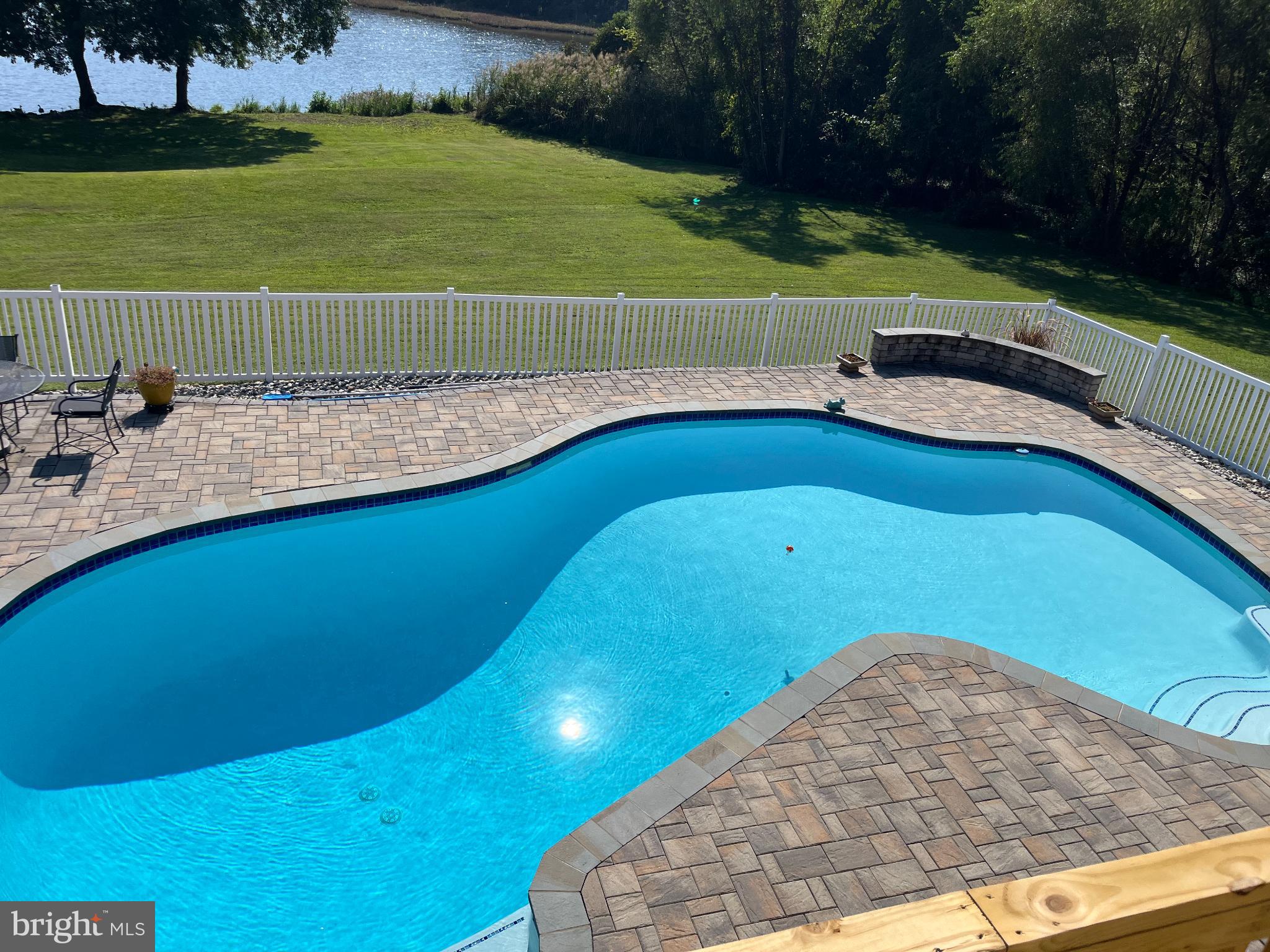 1419 Pond Ridge Drive Pasadena, MD 21122 - Photo 36 of 49 Serene poolside retreat with lush greenery.