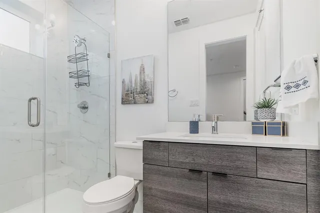 a bathroom with a double vanity sink toilet and shower