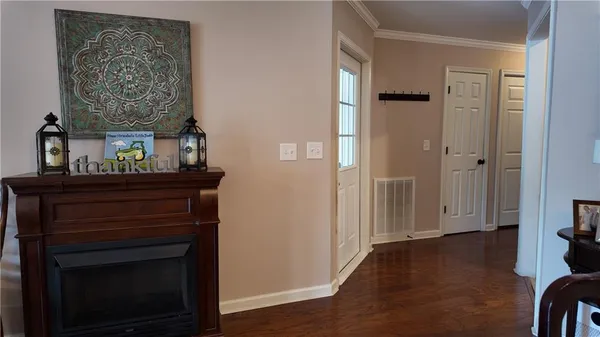 a view of a hallway with wooden floor and a fireplace