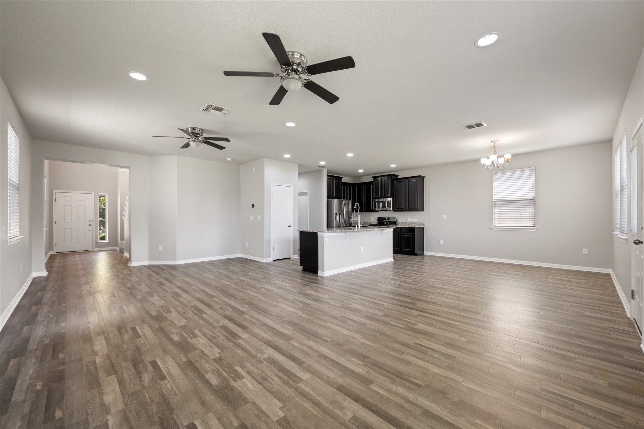 124 Guemal Road Buda, TX 78610 - Photo 8 of 40 An open-concept living space integrates a well-appointed kitchen and spacious living area with durable wood flooring.