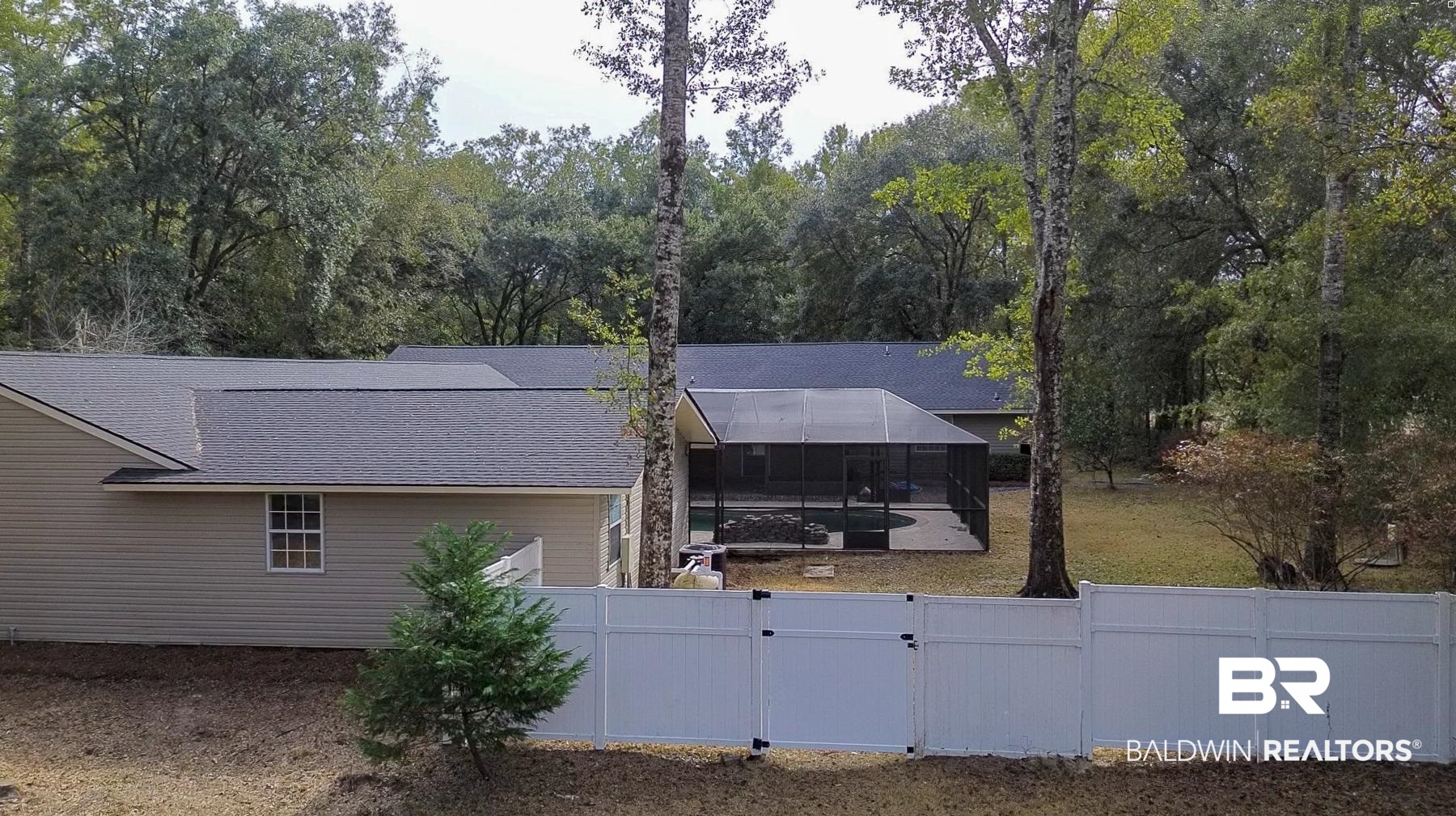 22711 Highway 98 Foley, AL 36535 - Photo 69 of 74 View of side of property featuring a sunroom, glass enclosure, a fenced backyard, a gate, and a shingled roof