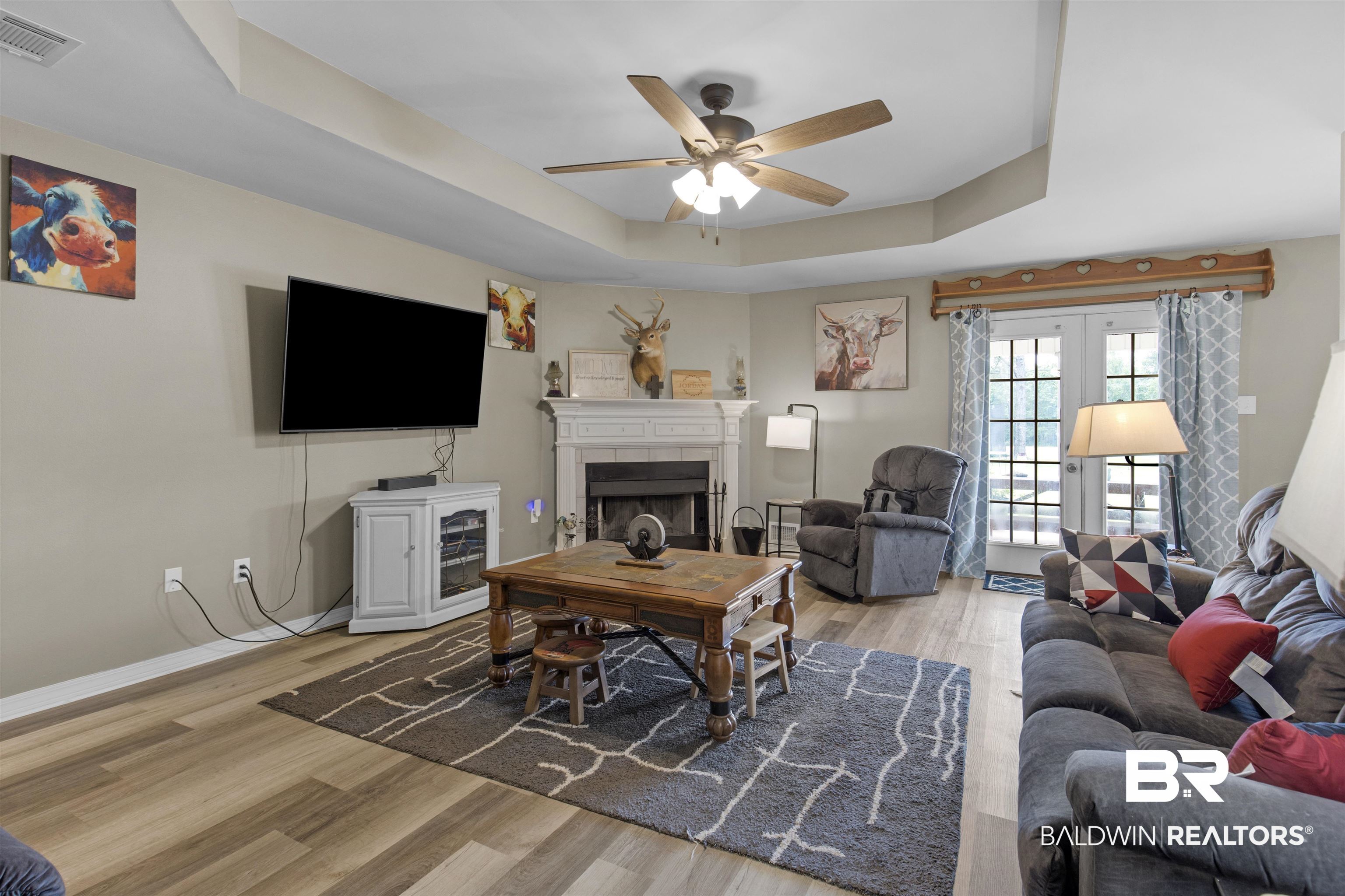 13925 Fort Lake Road Grand Bay, AL 36541 - Photo 4 of 37 Living area with ceiling fan, visible vents, a tiled fireplace, light wood finished floors, and a tray ceiling