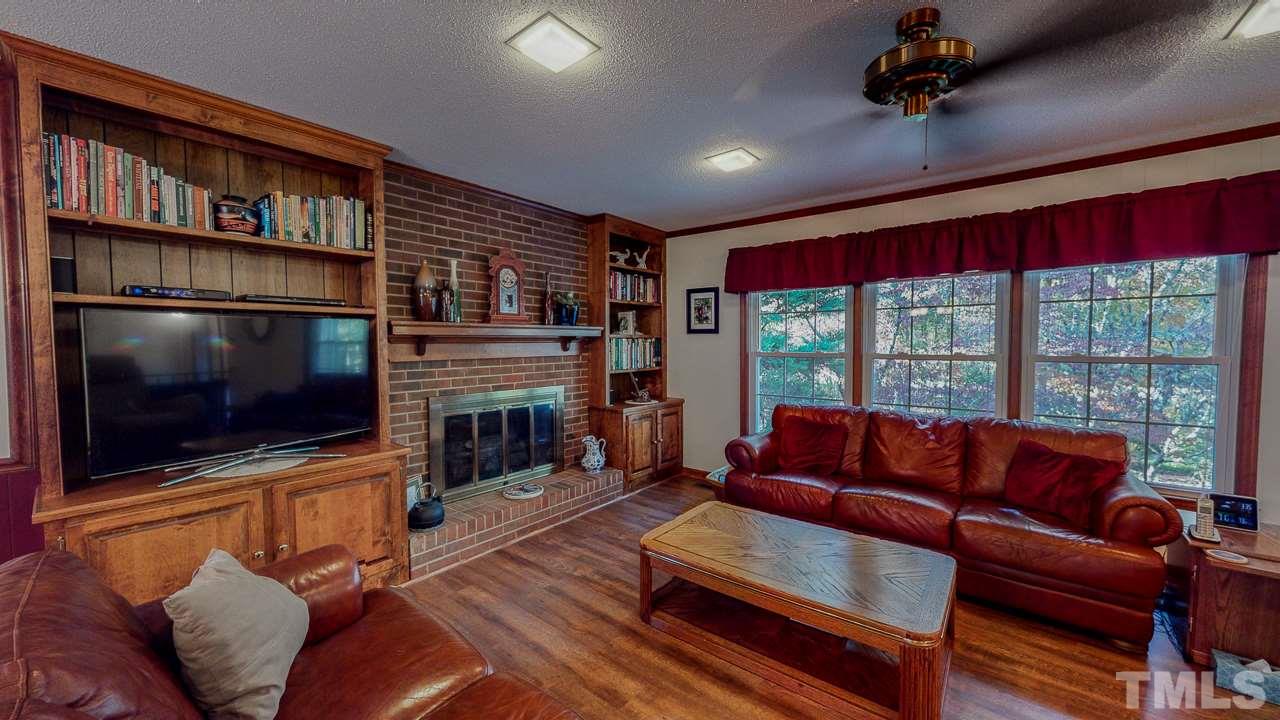 1307 Bill Poole Road Rougemont, NC 27572 - Photo 14 of 30 a living room with furniture a flat screen tv and a floor to ceiling window