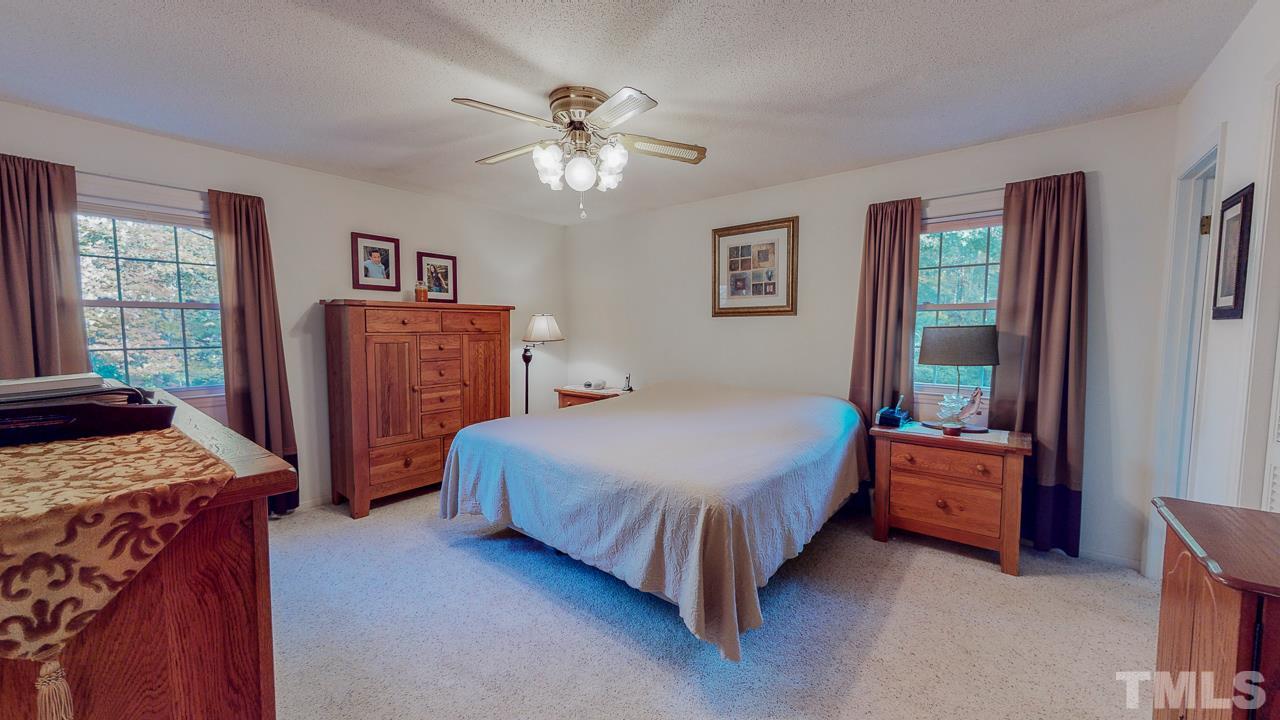 1307 Bill Poole Road Rougemont, NC 27572 - Photo 16 of 30 a bedroom with a bed and a chandelier