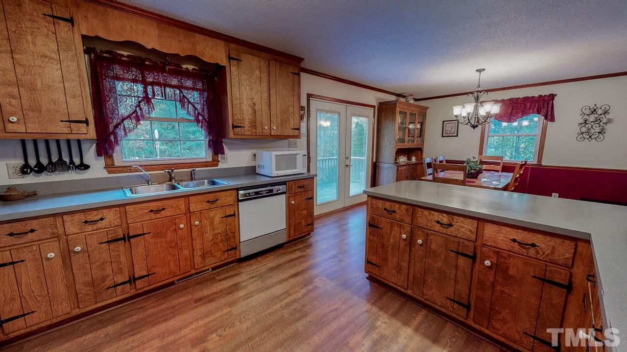 1307 Bill Poole Road Rougemont, NC 27572 - Photo 6 of 30 a kitchen with stainless steel appliances granite countertop wooden cabinets a stove a sink and a large window