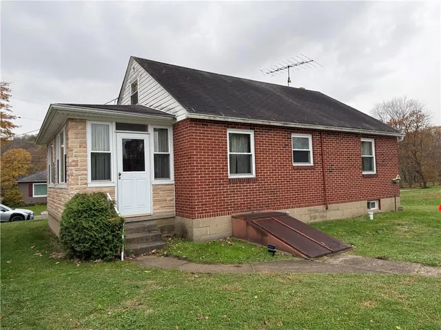 a backyard of a house with potted plants and large tree