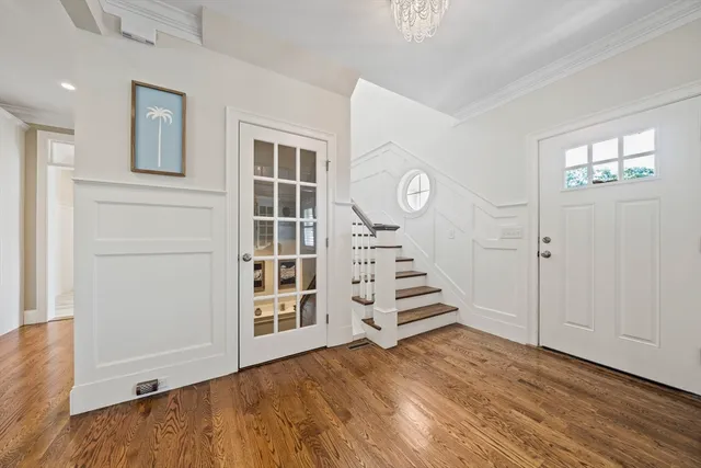 a view of a hallway with wooden floor and staircase