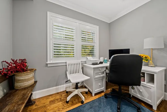 a view of a workspace with furniture and a window