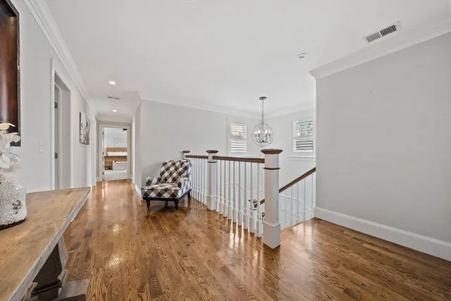 a hallway with wooden floor and furniture