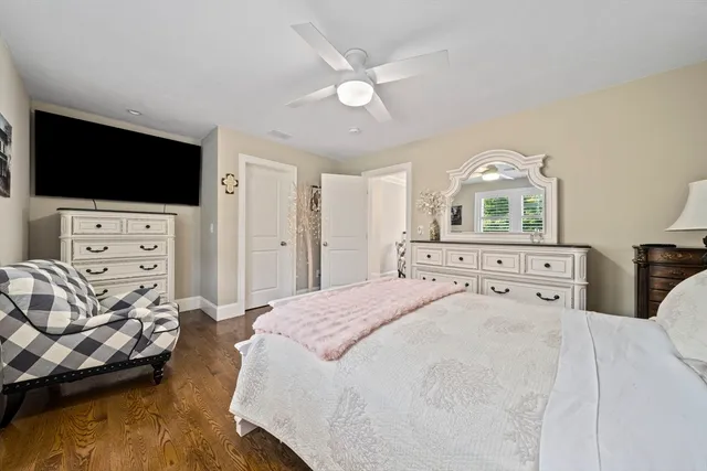 a bedroom with a bed a dresser and a flat screen tv