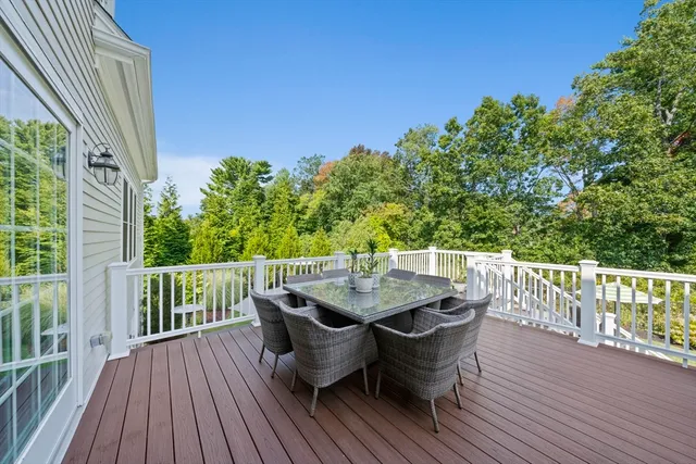 a patio with wooden floor table and chairs