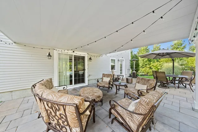 a view of a patio with couches table and chairs under an umbrella