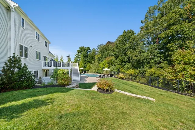 a backyard of a house with plants and large tree