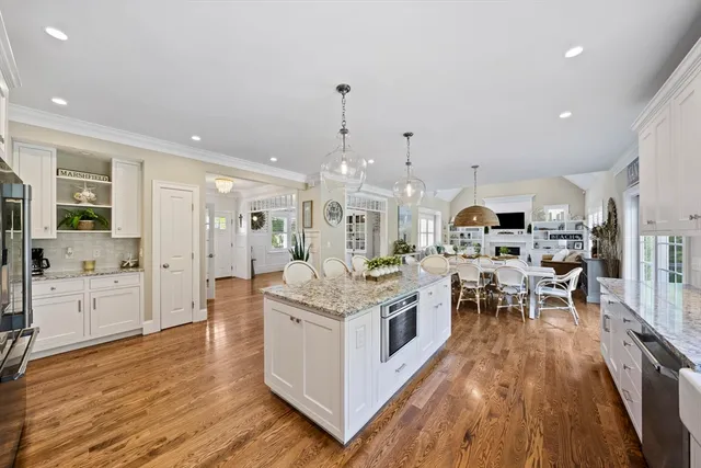 a large kitchen with stainless steel appliances and white cabinets