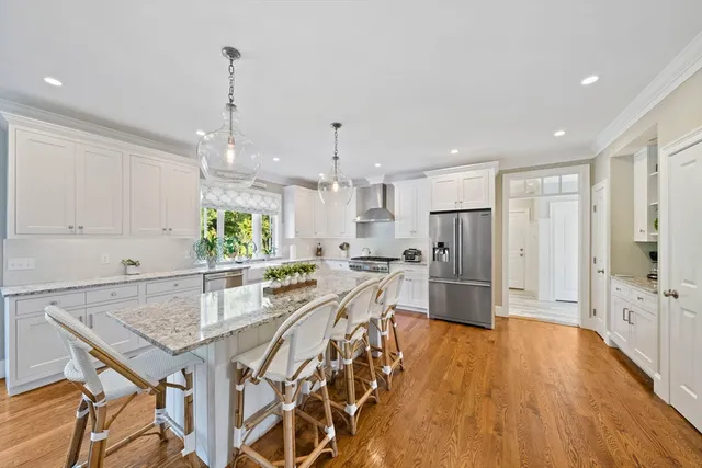 a kitchen with stainless steel appliances a dining table chairs stove and cabinets