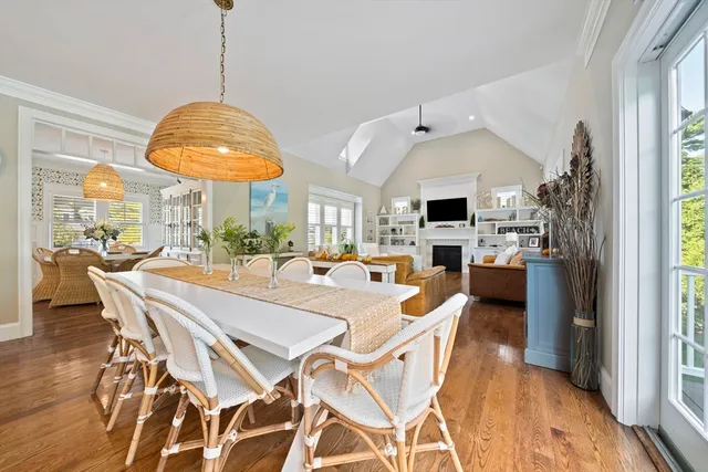 a view of a dining room and livingroom with furniture wooden floor a chandelier