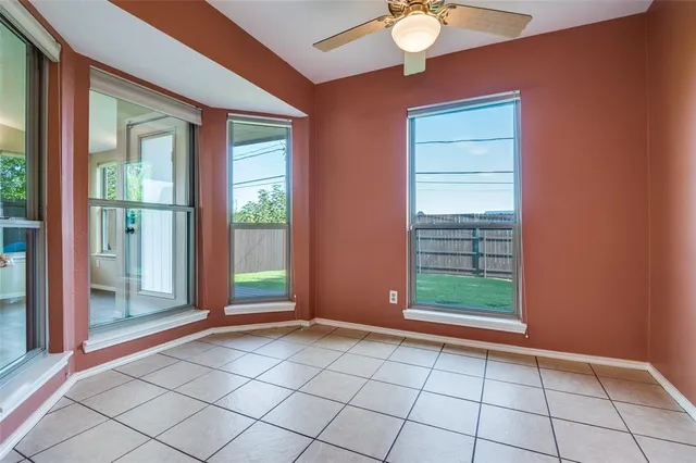 a view of an empty room with window chandelier fan and fire place