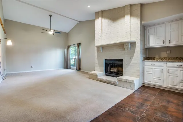 a view of an empty room with a fireplace and a window