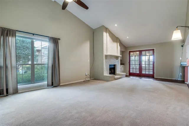 an empty room with fireplace and windows