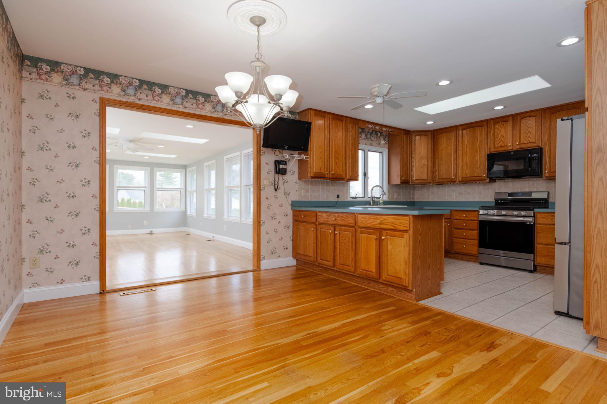 1909 Nelson Mill Road Jarrettsville, MD 21084 - Photo 24 of 65 a kitchen with stainless steel appliances granite countertop a stove top oven a sink dishwasher a dining table and chairs with wooden floor
