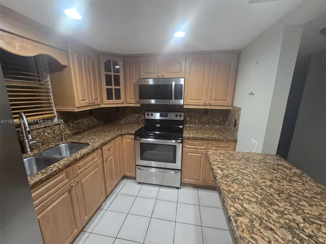 a kitchen with a stove top oven and cabinets