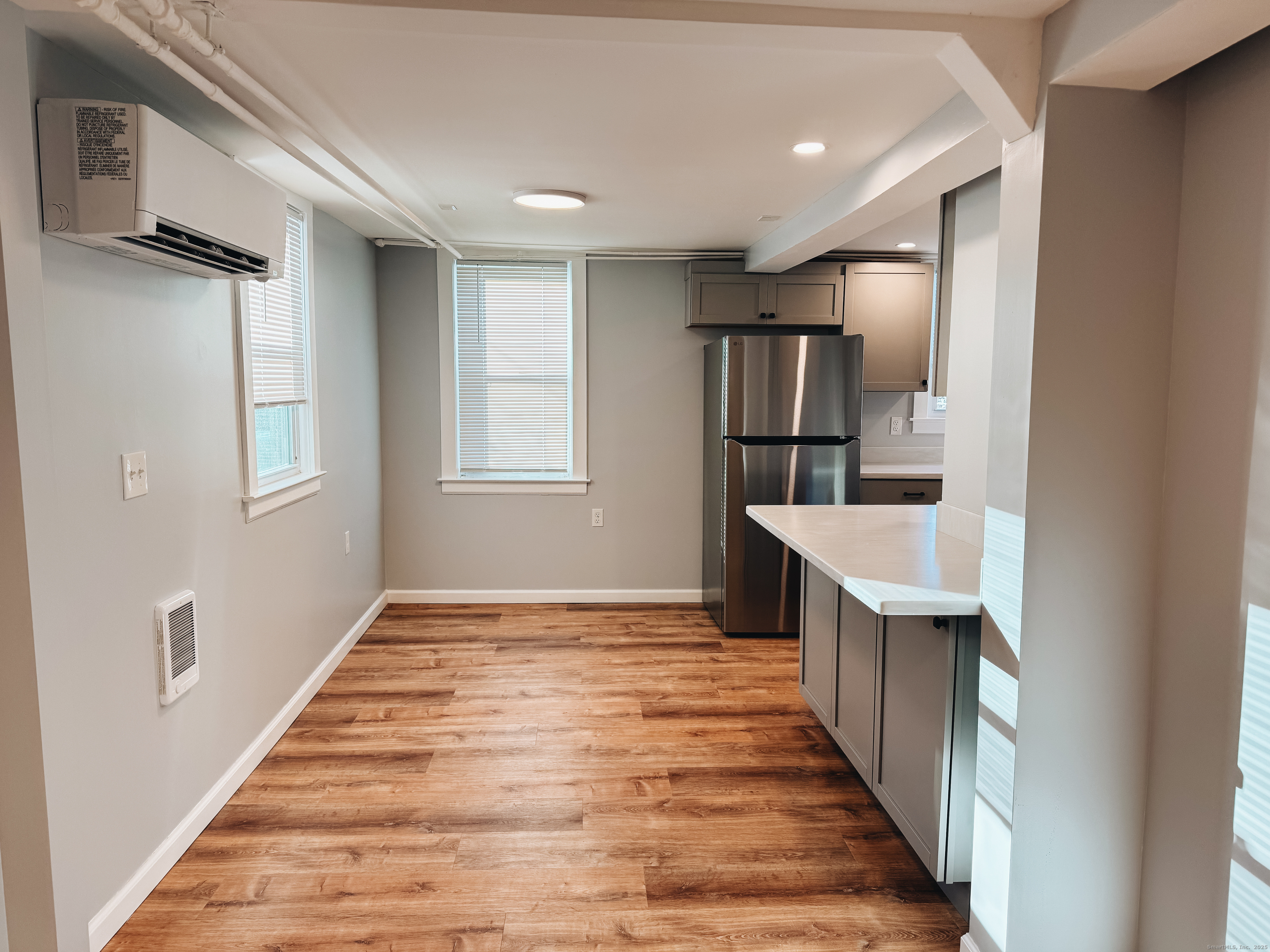 a view of kitchen and empty room with wooden floor