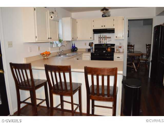 3233 Ransom Hills Road Richmond, VA 23237 - Photo 6 of 15 a kitchen with a dining table chairs and refrigerator